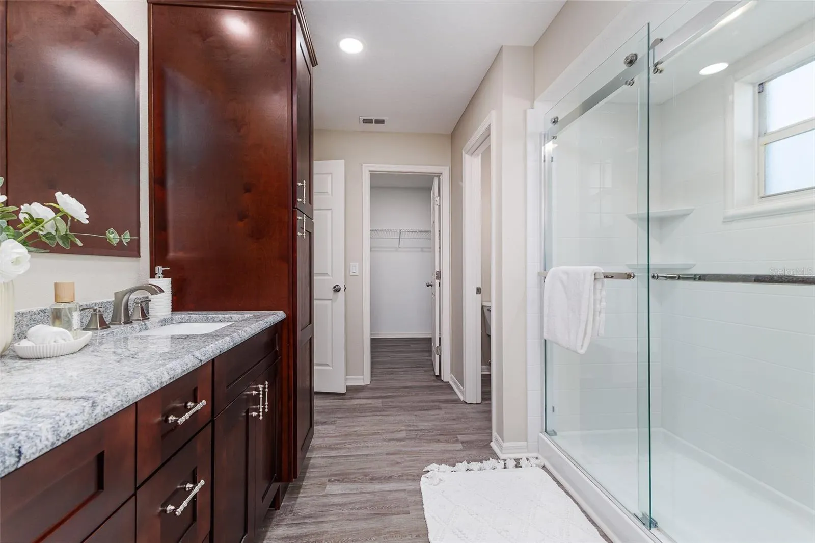 En Suite Primary Bath with Shower, dual sinks, stone countertops, plenty of storage, great lighting, and walk-in-closet, and water-closet toilet room.