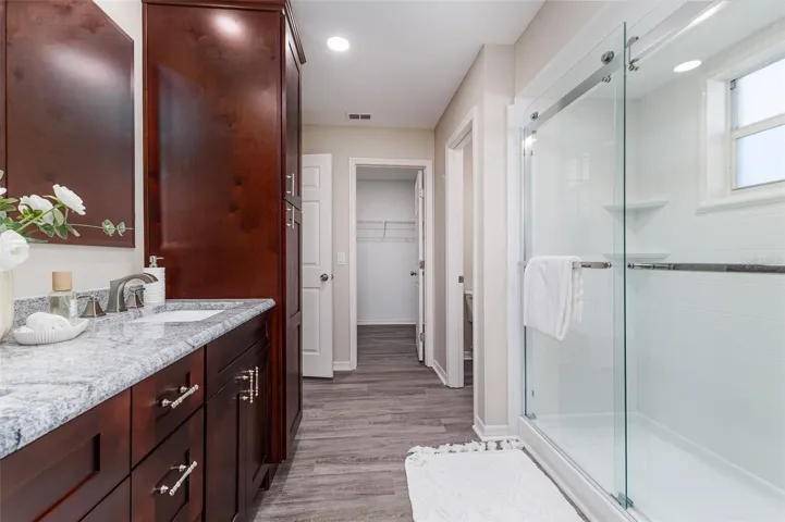 En Suite Primary Bath with Shower, dual sinks, stone countertops, plenty of storage, great lighting, and walk-in-closet, and water-closet toilet room.
