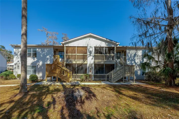 A well-maintained residential building surrounded by mature trees and landscaped common areas, offering a welcoming condo community setting.