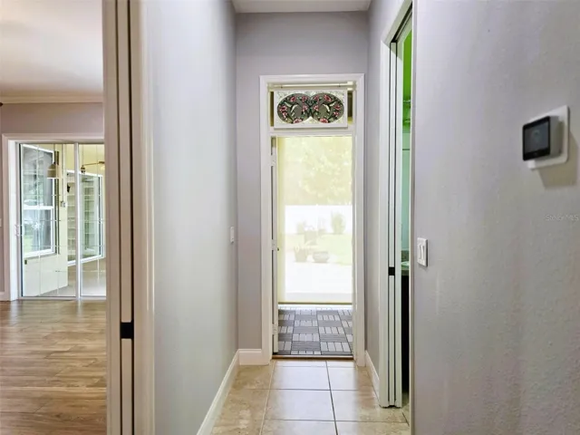MIL Hall-pocket door to left separates main house, ful bath to right and sunroom/entry straight ahead