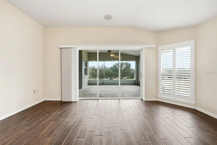 Great Room with plantation shutters and pocket triple sliding doors to lanai with golf course view!