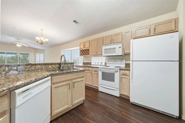 Plenty of cabinet space, Solid Surface Countertops, built-in wine rack and open to great room and golf course view!