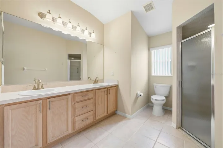 Primary Bathroom with dual sinks, linen and shower