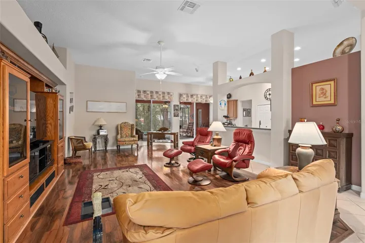 Great Room with 11' Ceilings and Bose Surround Sound and a view of he pool and wooded yard
