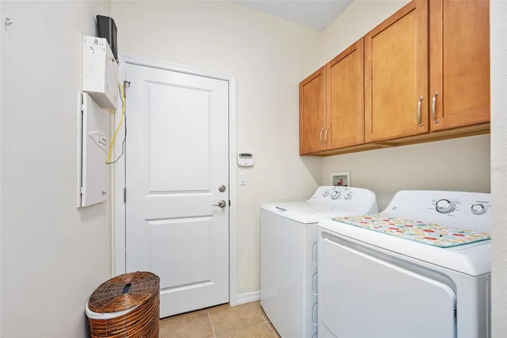 Laundry with cabinet storage above