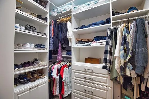 Master bedroom walk in closet with built in shelving
