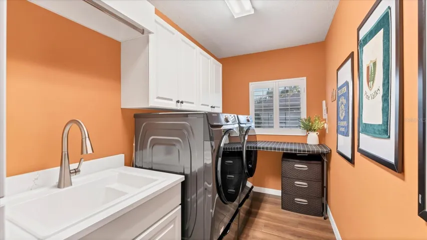 Laundry room with all the extras! 2nd refrigerator, storage cabinetry, and utility sink.