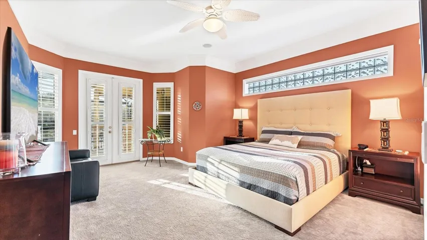 Thoughtfully designed primary bedroom offers gorgeous views of pool and expansive golf course views.