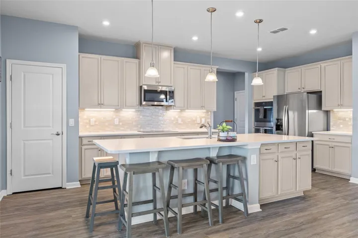 Kitchen with upgraded quartz countertops and glass tile backsplash