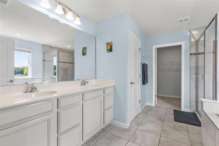 Primary ensuite bath features double sinks and quartz cabinets