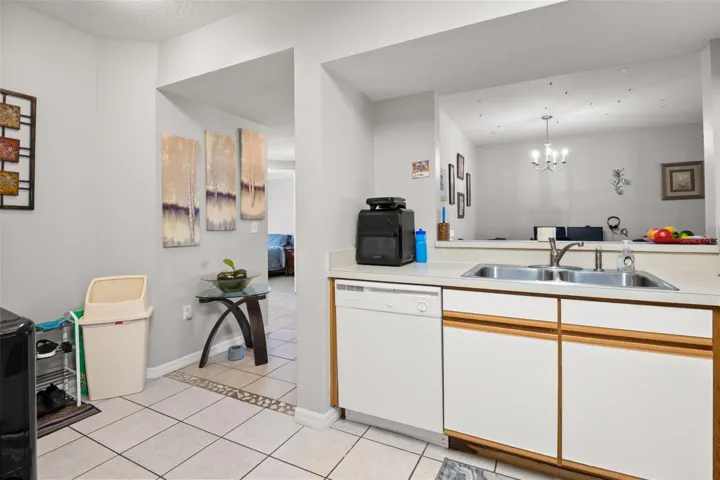 Spacious kitchen with double-basin sink, dishwasher, and extended counter space overlooking the main living area. The breakfast bar enhances the open layout while maintaining separation between kitchen and dining spaces.