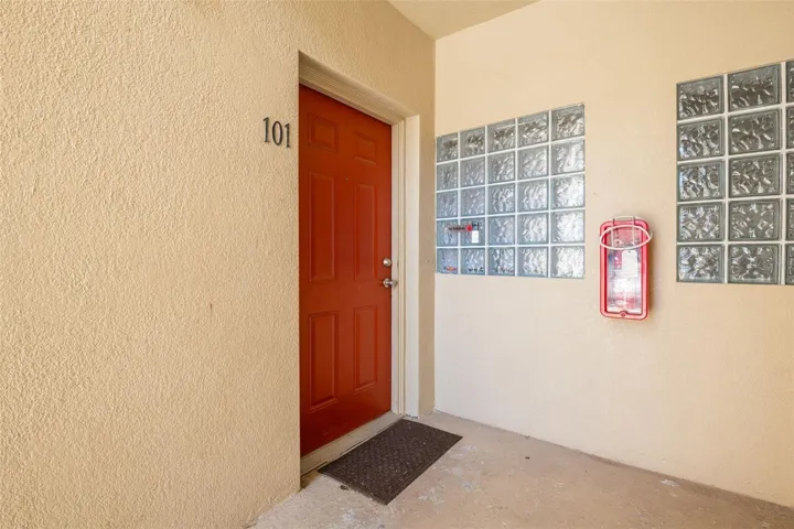Welcoming covered entry featuring a distinctive front door and protected alcove for added privacy. The sheltered design offers convenient, weather-protected access and a defined sense of arrival into this first-floor residence.