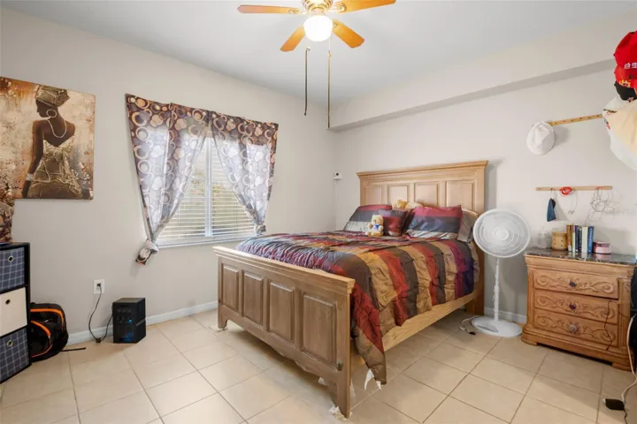 Spacious primary suite featuring ceramic tile flooring and a large window that brings in natural light. The room comfortably accommodates full-size furnishings while maintaining an open feel.