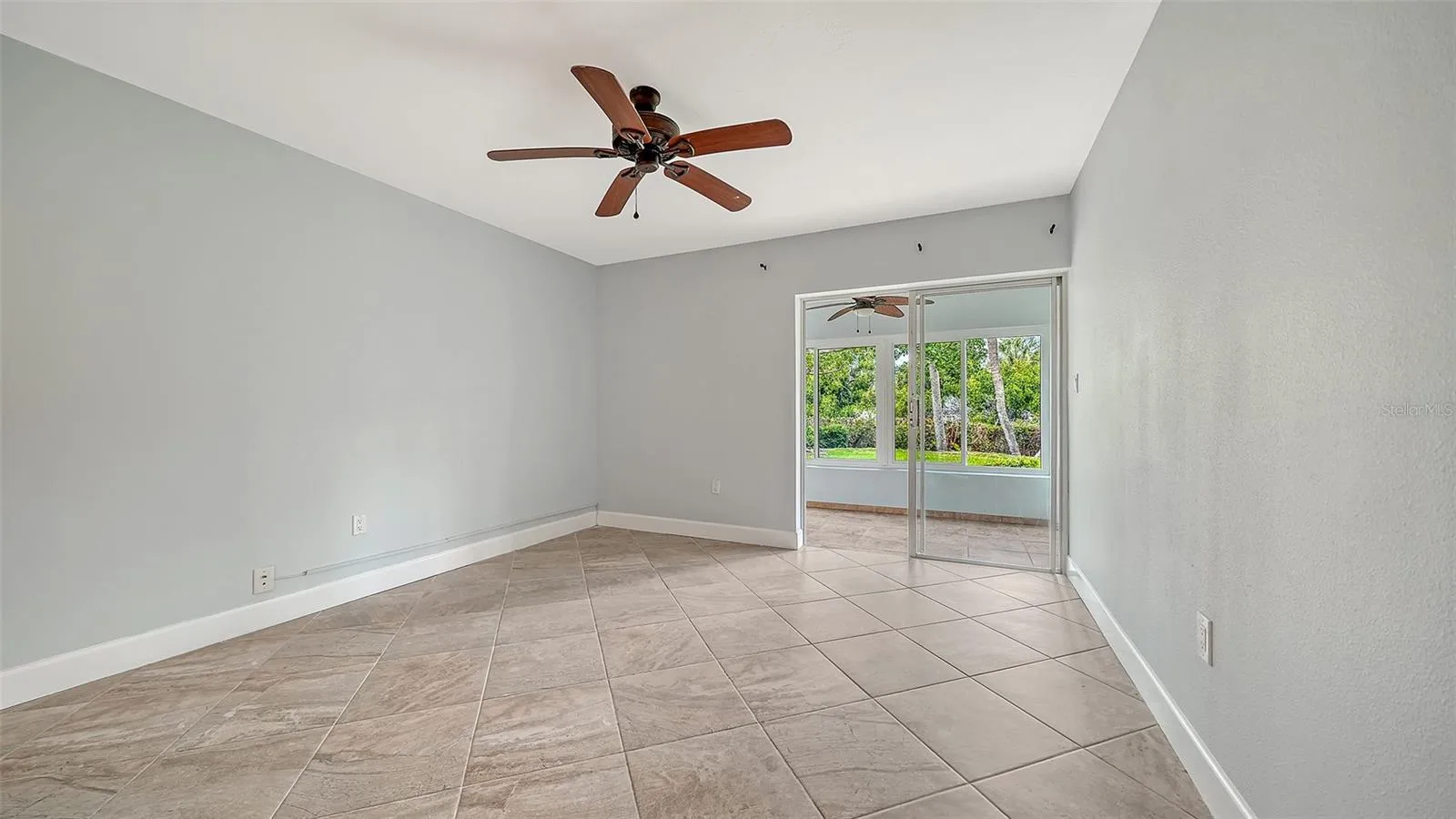 Guest bedroom also features floor to ceiling sliders leading to the lanai.