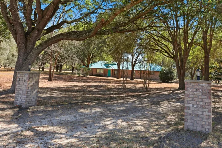 Front view of home from driveway entry columns.