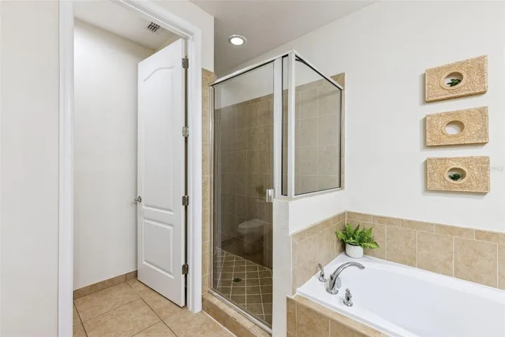 En suite Primary Bathroom with garden tub, separate shower stall, and private toilet/WC