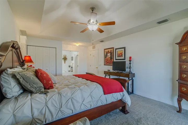 Master Bedroom with Built-in Closet and Tray Ceiling with Fan