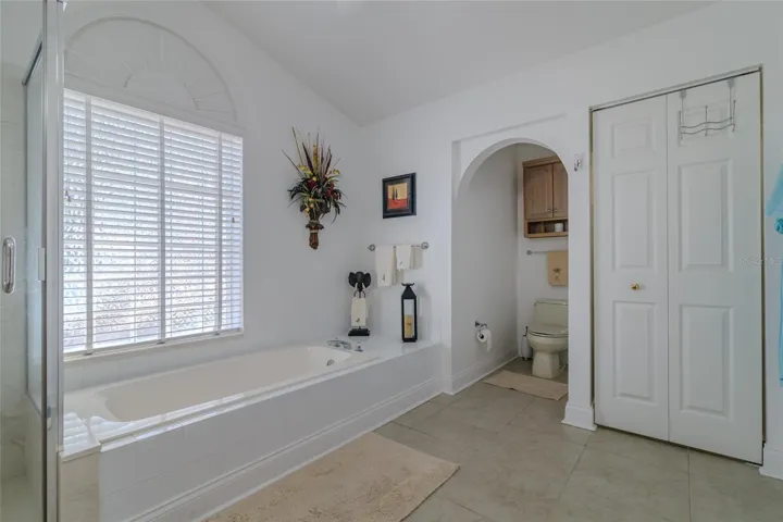 Master Bathroom with Soaking Tub, Tile Floors and a walk-in closet