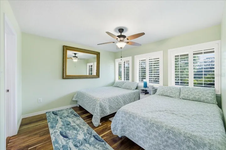 Second bedroom at the front of the unit with its own tastefully updated en-suite bathroom, three windows, beautiful wood-look tile flooring, decorative ceiling fan and California Closet.