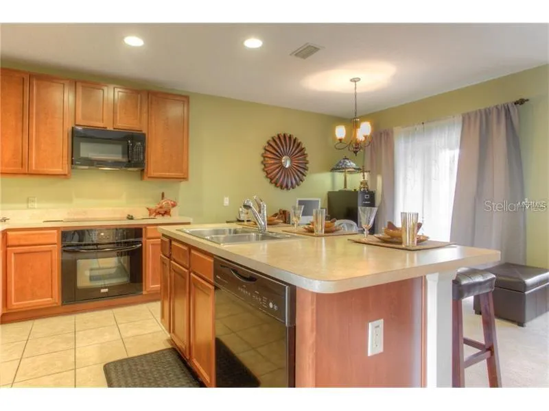 Wood Cabinets, Black Appliances with Island/Breakfast Bar