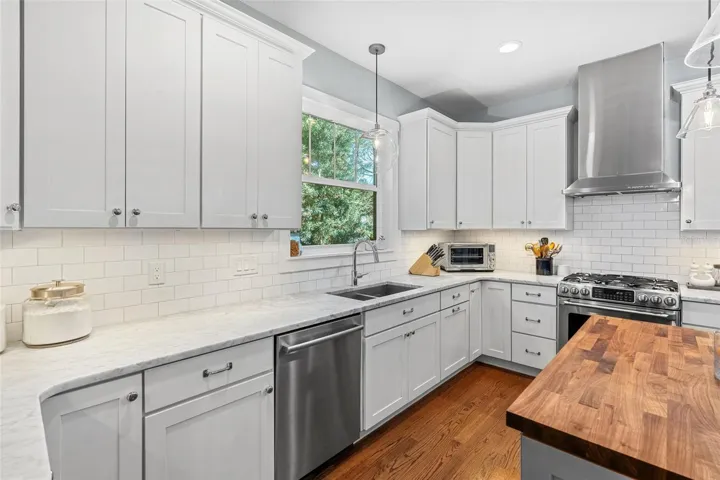 Shaker cabinets with marble counters, vent hood and walk-in pantry