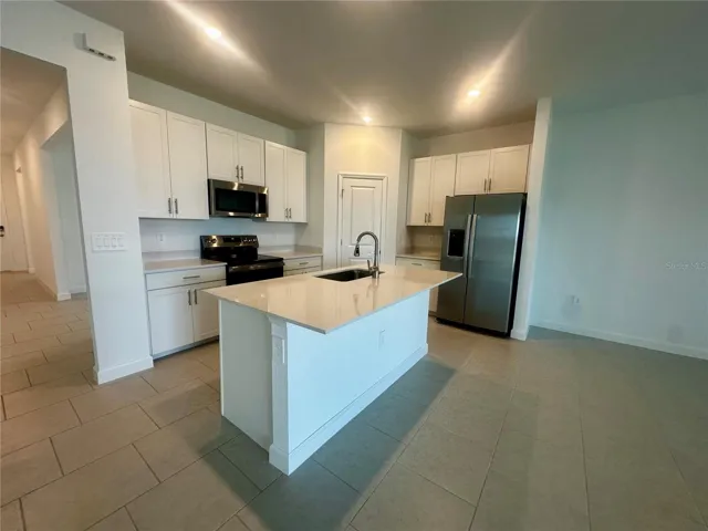 Quartz countertops, white shaker cabinetry and stainless steel  appliances