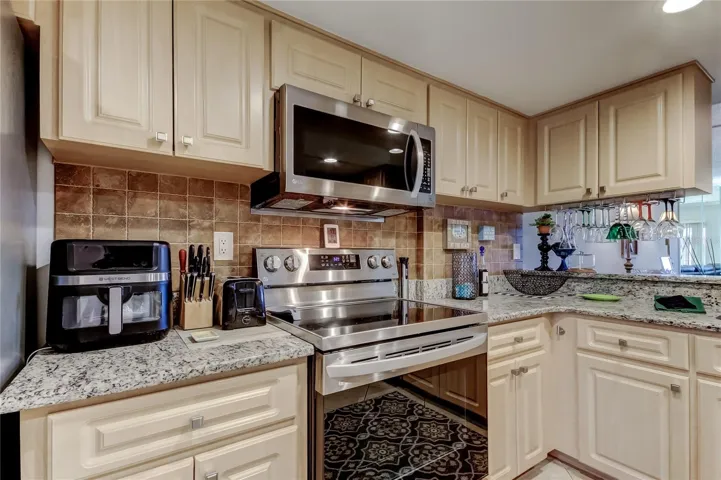 Another view of the kitchen showing the range and microwave.
