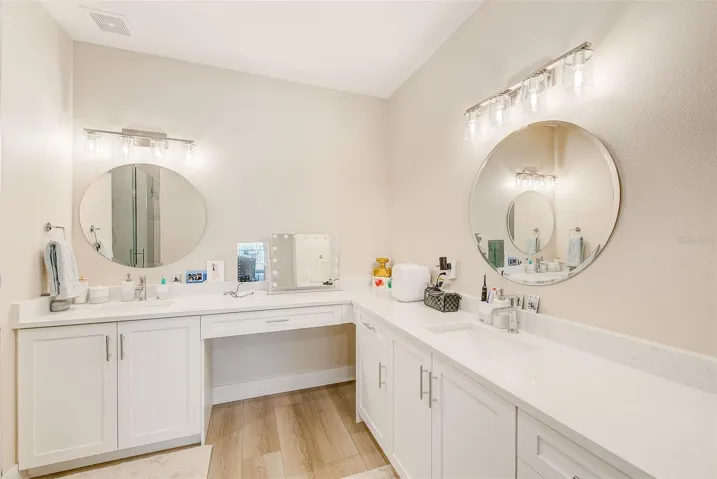 Dual sink and vanity with quartz countertops.