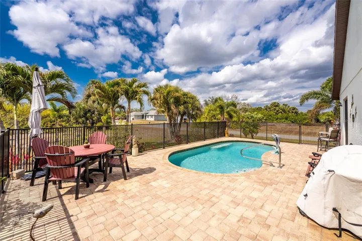 Paver decking and decorative new aluminum fencing surround the pool area