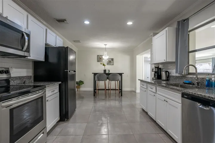 Modern kitchen featuring brand-new granite countertops and a full suite of newer appliances.