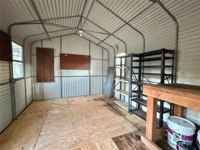 Extra large shed has pegboards and shelving.