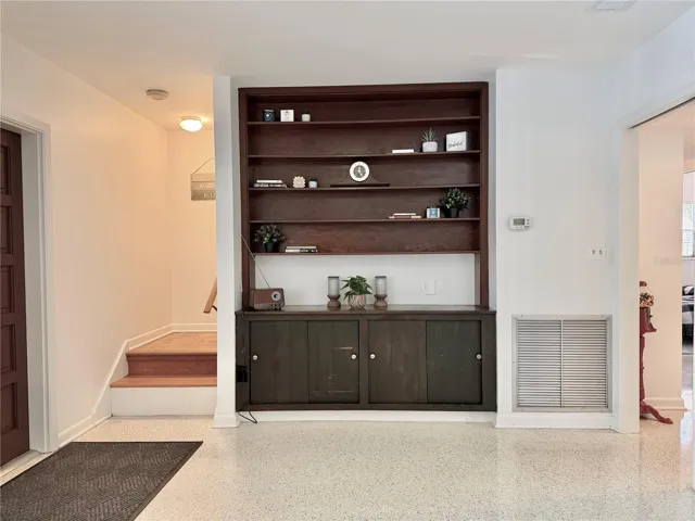 The Living Room has built-in shelving and overlooks the pool through a large window.
