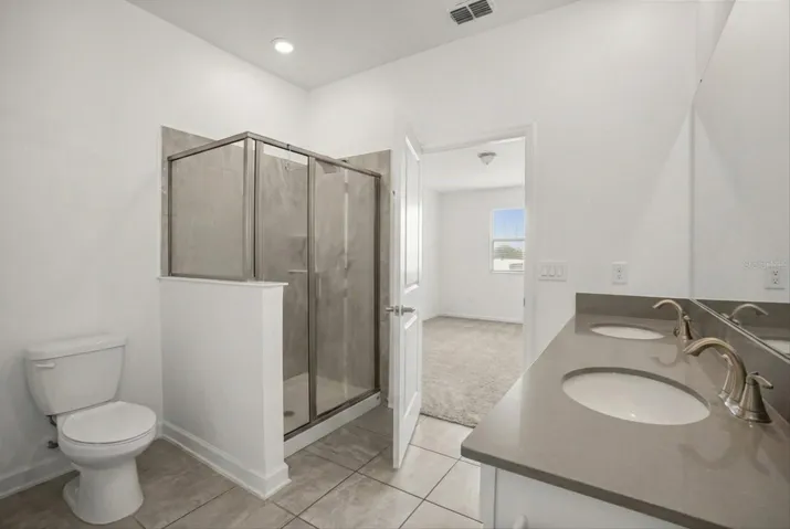 Primary bathroom with shower and modern finishes.