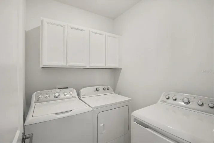 Laundry room with washer, dryer,and  cabinets.