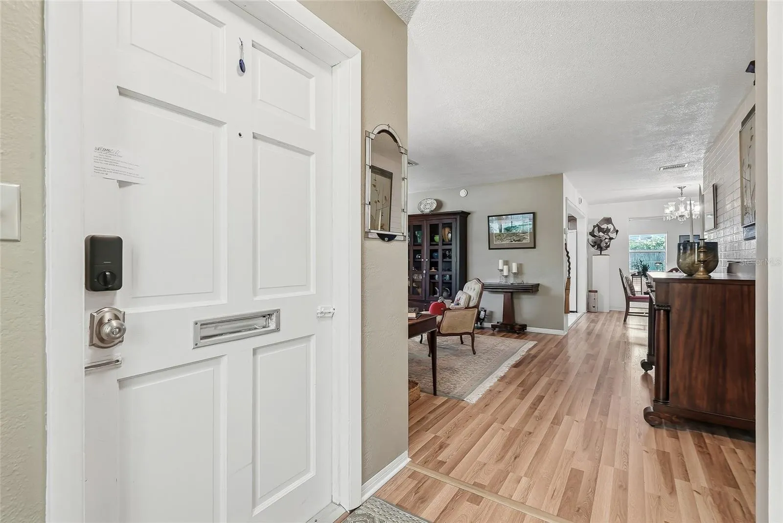 An inviting entry opens to comfortable living spaces, with warm wood flooring connecting the living and dining areas.