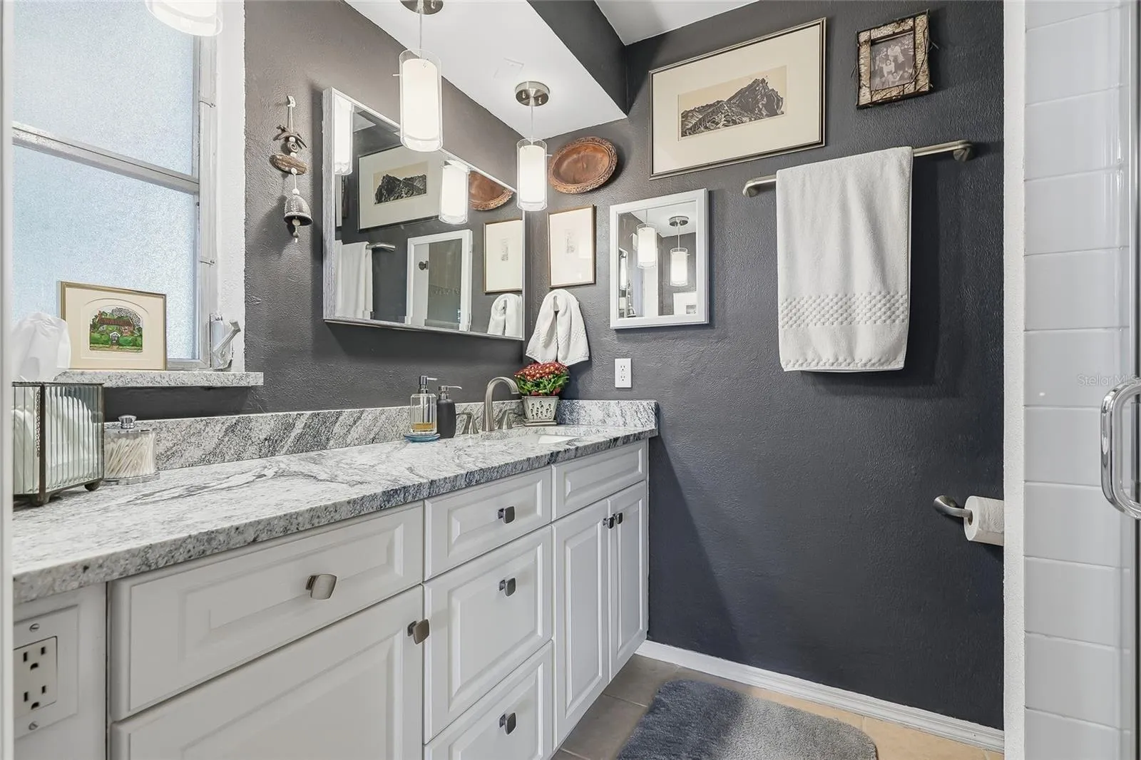Start your day with generous vanity space, plentiful drawer storage, and pendant lighting that adds a stylish touch to the primary bath.