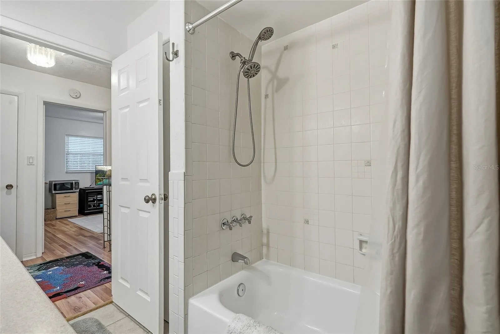 Enjoy the flexibility of a full tub and shower combination, finished with classic white tile and a handheld showerhead.