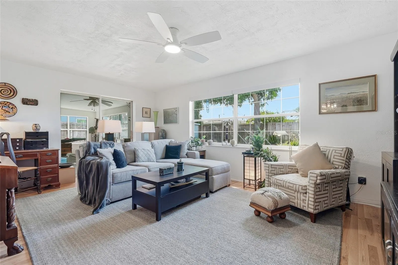 Sunlight pours through a wide window in the family room, while sliding glass doors connect this comfortable gathering space to the enclosed Florida room.