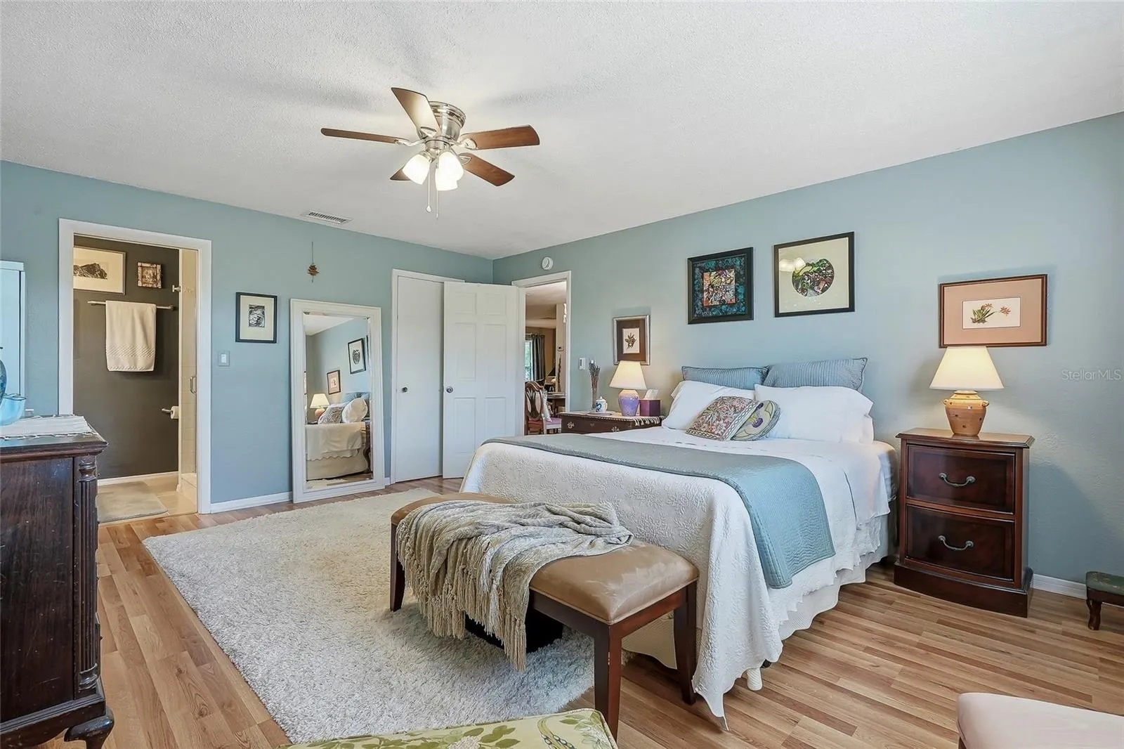 Unwind in a generously sized primary suite with warm wood flooring and the everyday convenience of a private ensuite bath.