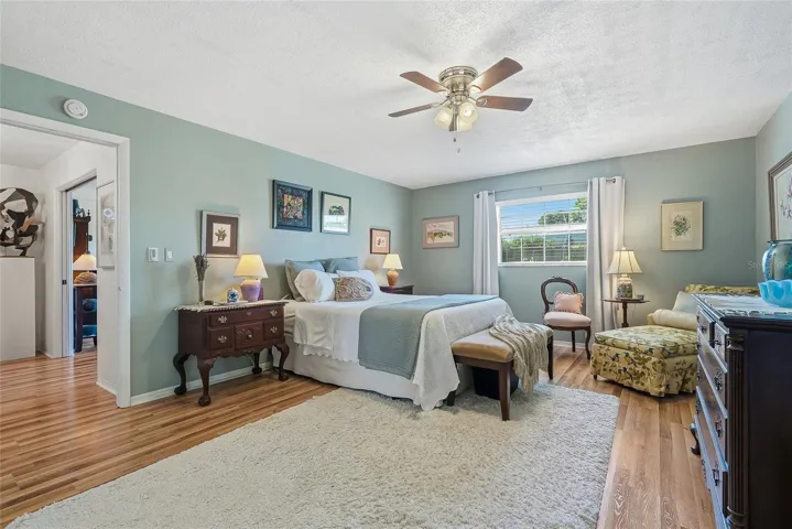 More than a place to sleep, this spacious primary bedroom offers room for a cozy reading corner beside the window.