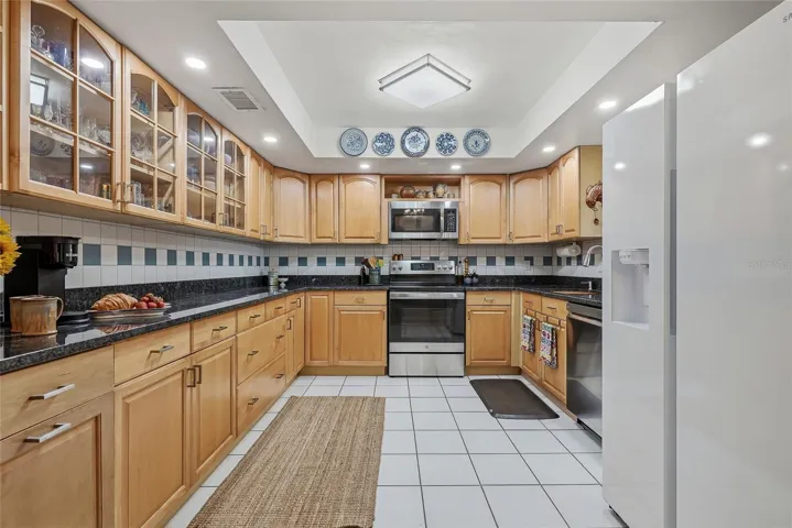 Spread out and create in a kitchen featuring generous counter space, abundant cabinetry, and glass-front cabinets to showcase your favorite pieces.