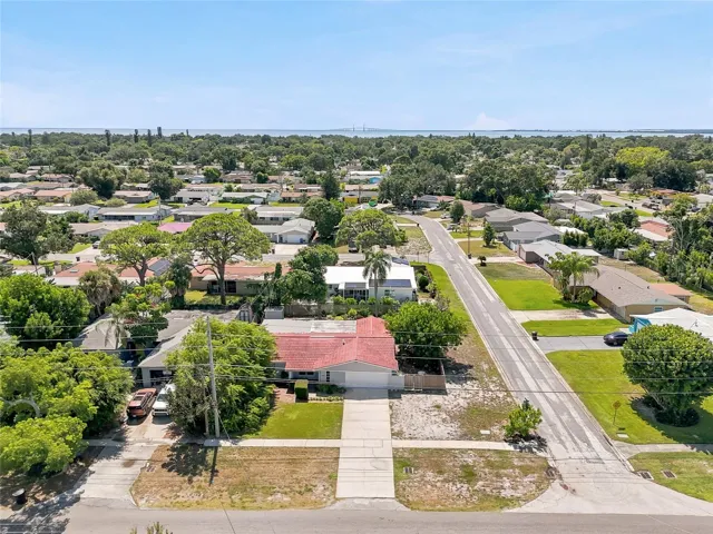 See the corner setting from above, with a broad driveway, mature trees, and generous outdoor space surrounding the home.