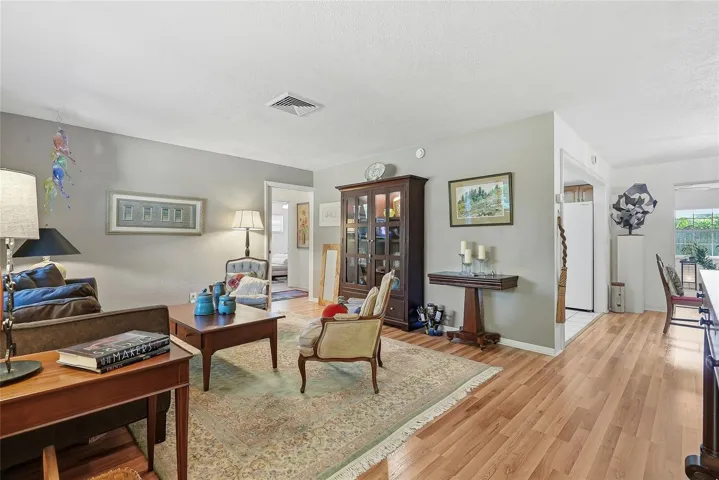 Room to gather and unwind. The spacious living room offers flexible furniture arrangements and easy access to the kitchen, dining area and guest bedrooms, separated by a working pocket door.