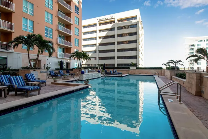 Resort-style pool deck at 1350 Main with fire pit, spa, outdoor showers, BBQ grill
