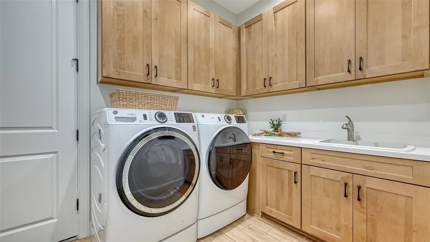 Laundry room has utility sink, folding counter, and laundry hanging rod