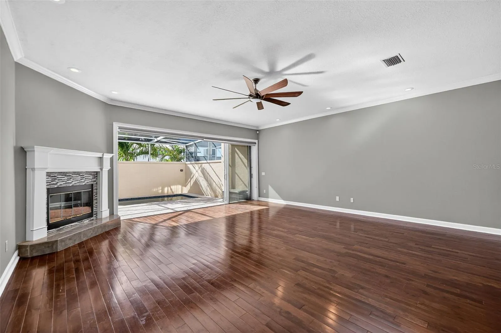 The Famlily Great room has a wood burnint fireplace and doors that open completely out to you enclosed screened pool area for great indoor outdoor living