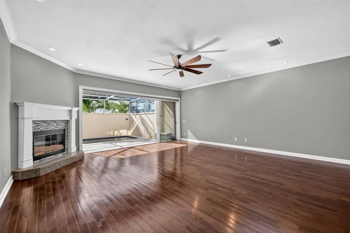 The Famlily Great room has a wood burnint fireplace and doors that open completely out to you enclosed screened pool area for great indoor outdoor living