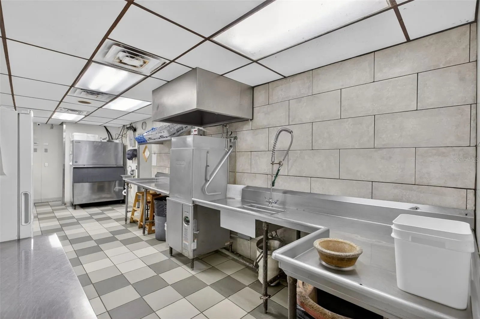 Fully equipped commercial kitchen infrastructure including hood system, fryers, ranges, griddles, and prep stations.