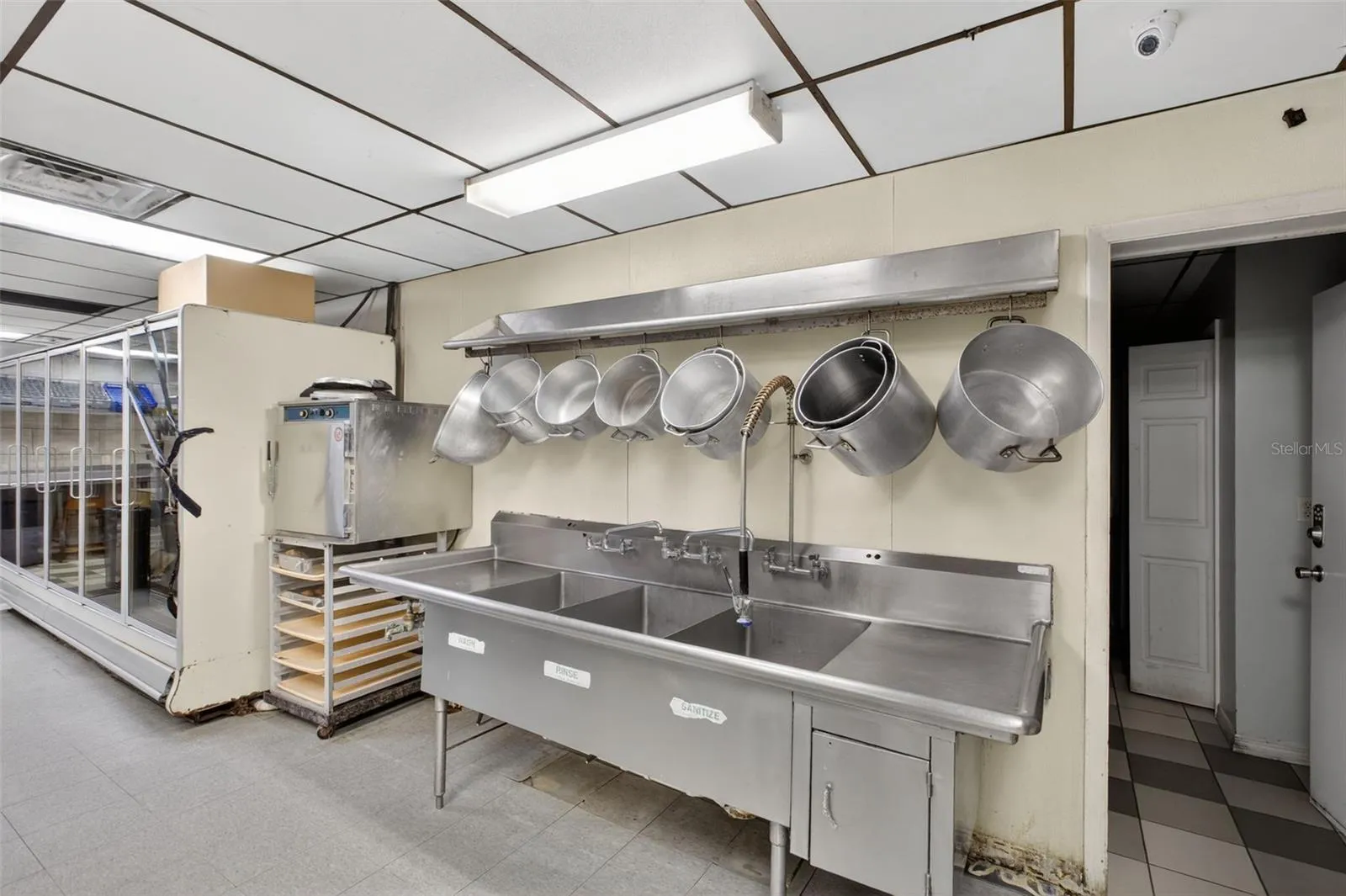 Fully equipped commercial kitchen infrastructure including hood system, fryers, ranges, griddles, and prep stations.
