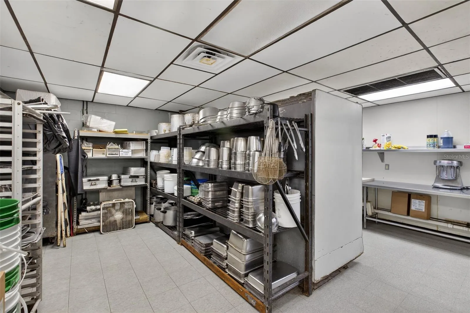 Fully equipped commercial kitchen infrastructure including hood system, fryers, ranges, griddles, and prep stations.